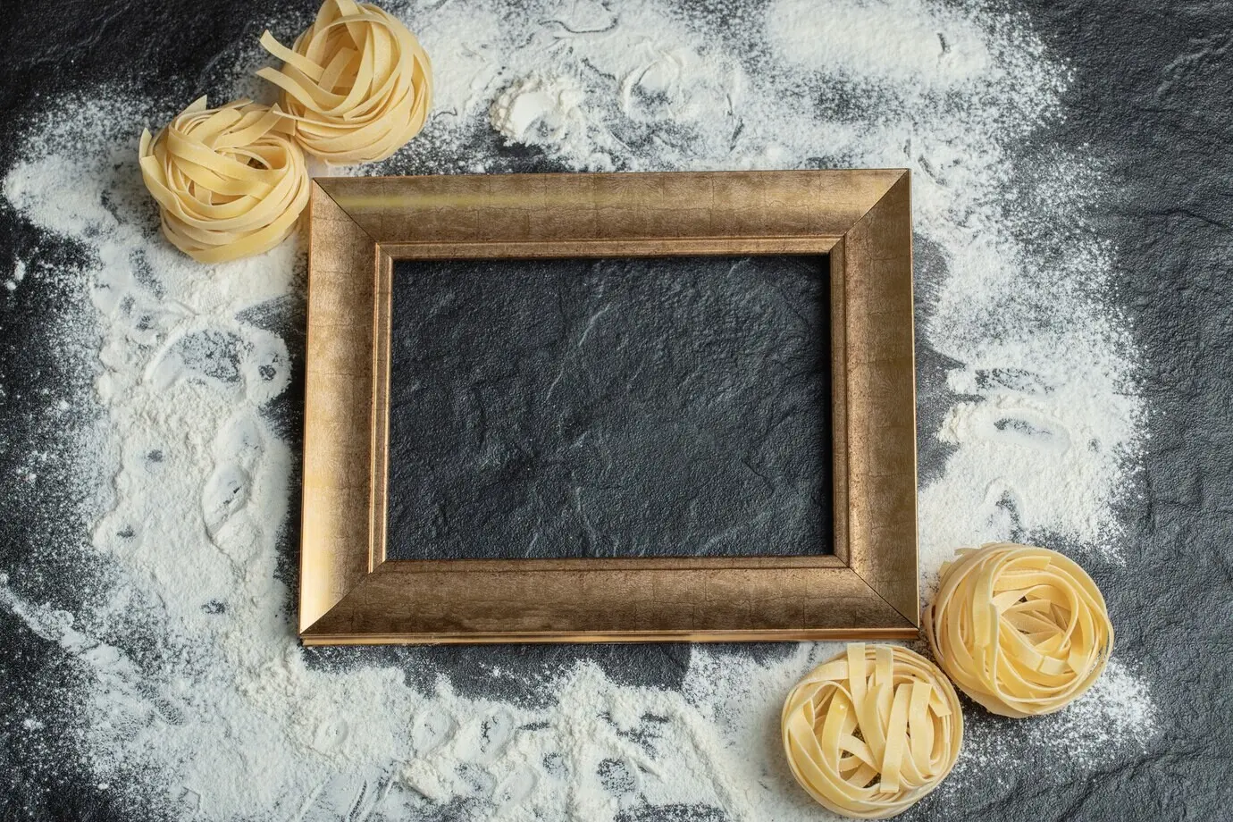Rohe Nestnudeln mit Mehl und Rahmen auf schwarzem Hintergrund.